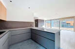 This modern kitchen boasts sleek, gray cabinetry and a stylish countertop, perfect for culinary enthusiasts.