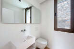 This modern bathroom features a sleek, minimalist design with a wall-mounted sink and toilet.