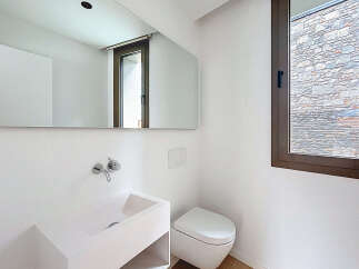 This modern bathroom features a sleek, minimalist design with a wall-mounted sink and toilet.