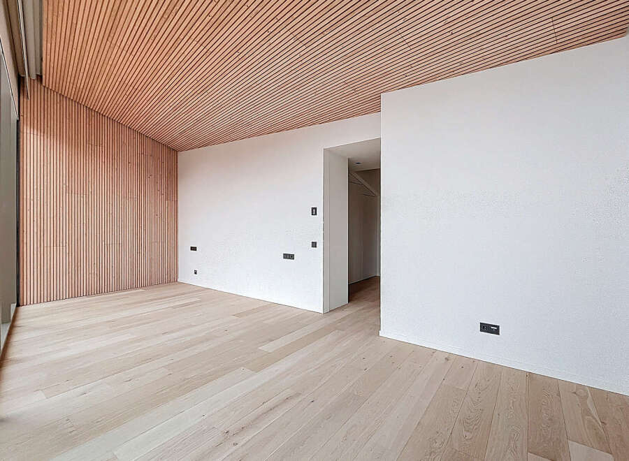 This modern space features a stunning wooden ceiling and accent wall, creating a warm and inviting atmosphere.