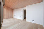 This modern space features a stunning wooden ceiling and accent wall, creating a warm and inviting atmosphere.
