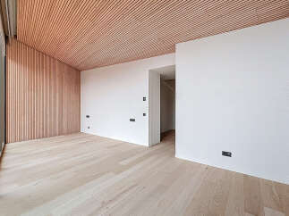 This modern space features a stunning wooden ceiling and accent wall, creating a warm and inviting atmosphere.