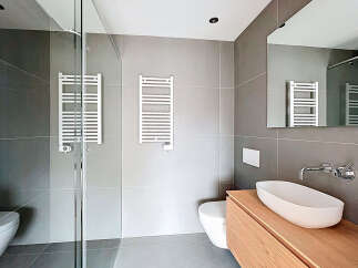 Step into a modern bathroom oasis! This stylish space features sleek gray tiles, creating a clean and contemporary aesthetic.