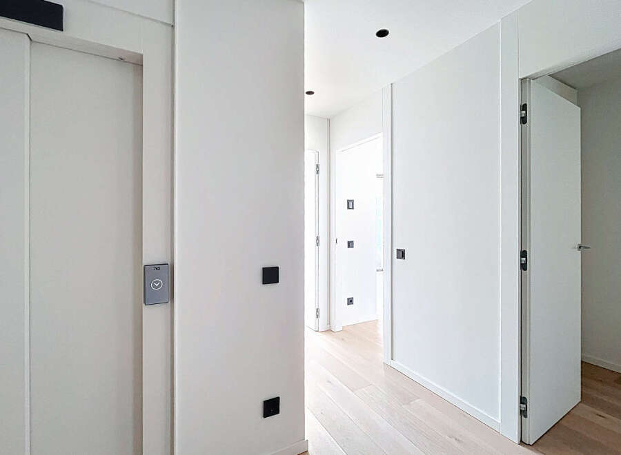 Step into a modern, minimalist hallway with clean lines and a bright, airy feel.