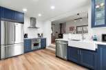 This stunning kitchen boasts modern design with navy blue cabinetry and stainless steel appliances.