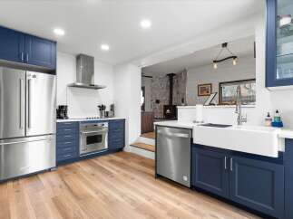 This stunning kitchen boasts modern design with navy blue cabinetry and stainless steel appliances.