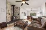 Cozy up in this charming living space featuring a stunning stone fireplace, perfect for those chilly evenings.