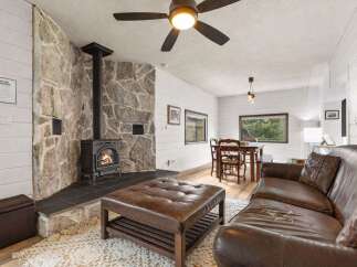 Cozy up in this charming living space featuring a stunning stone fireplace, perfect for those chilly evenings.