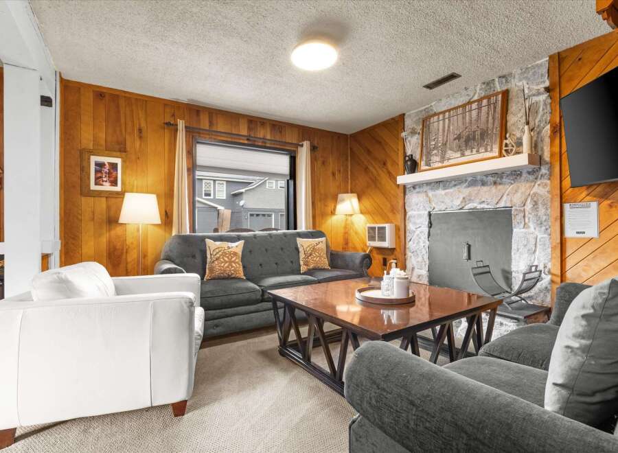 Step into a cozy living space with a charming stone fireplace, perfect for those chilly evenings.