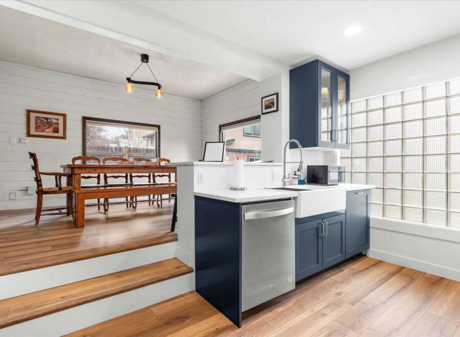 This stunning kitchen features a modern design with sleek blue cabinetry and a stainless steel dishwasher.