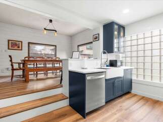 This stunning kitchen features a modern design with sleek blue cabinetry and a stainless steel dishwasher.