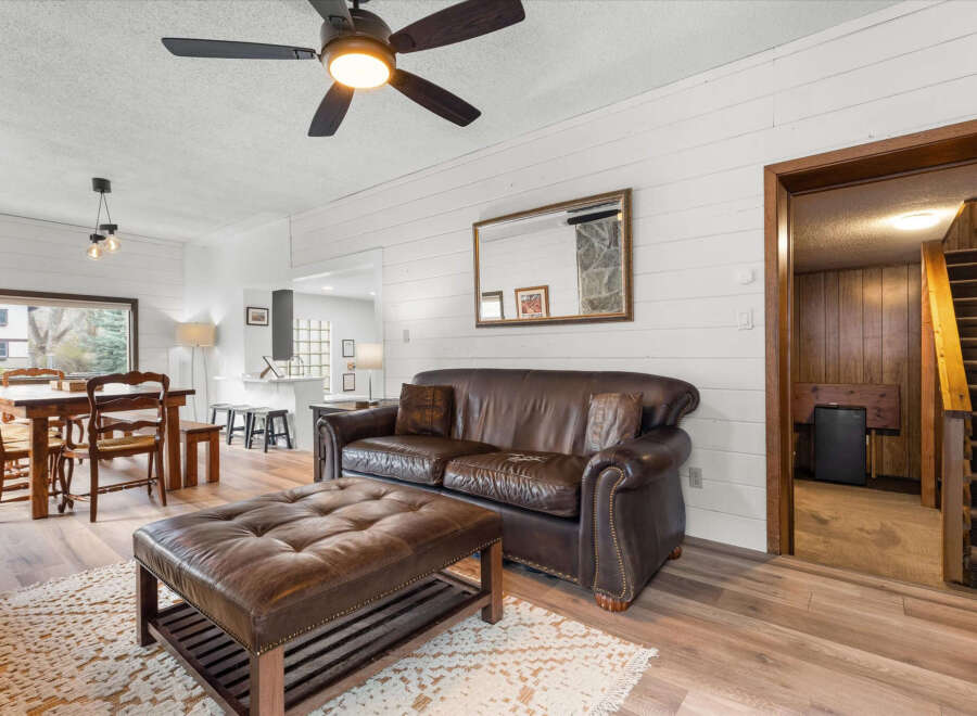 Step into this inviting living space, featuring a cozy leather sofa and ottoman, perfect for relaxation.