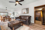Step into this inviting living space, featuring a cozy leather sofa and ottoman, perfect for relaxation.