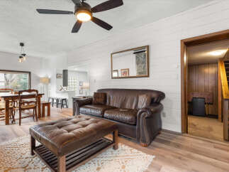 Step into this inviting living space, featuring a cozy leather sofa and ottoman, perfect for relaxation.