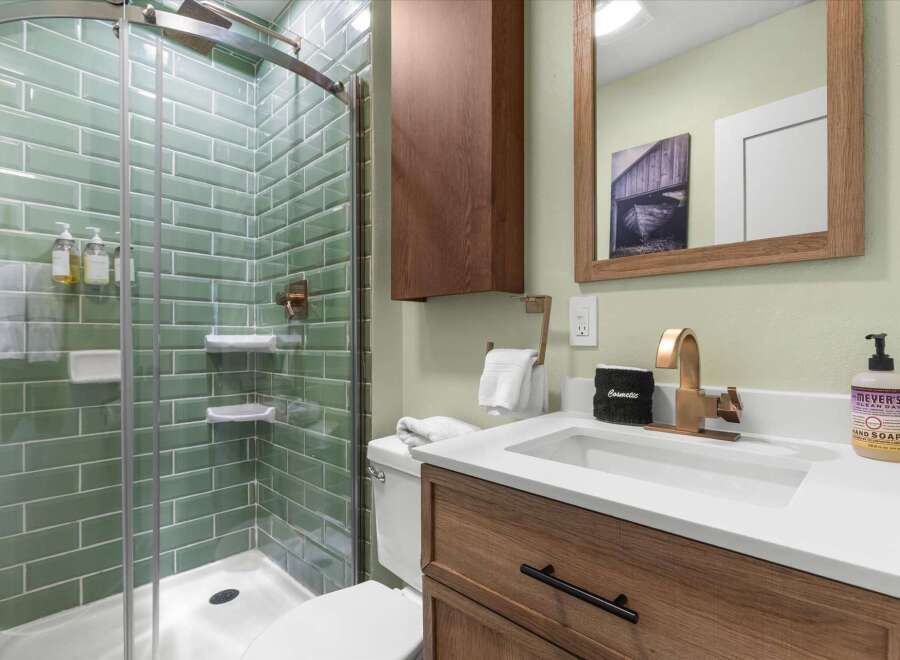 Step into a beautifully designed bathroom featuring a modern glass shower with stylish green tile.