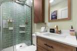 Step into a beautifully designed bathroom featuring a modern glass shower with stylish green tile.
