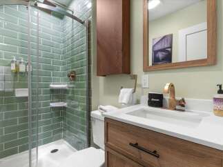 Step into a beautifully designed bathroom featuring a modern glass shower with stylish green tile.