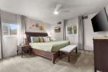 Step into this inviting bedroom, featuring a luxurious king-sized bed and a stylish bench at the foot.