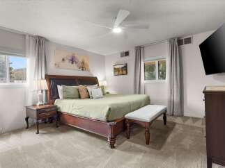 Step into this inviting bedroom, featuring a luxurious king-sized bed and a stylish bench at the foot.