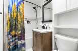 This stunning bathroom features a unique shower curtain with a vibrant nature scene, creating a serene and inviting atmosphere.