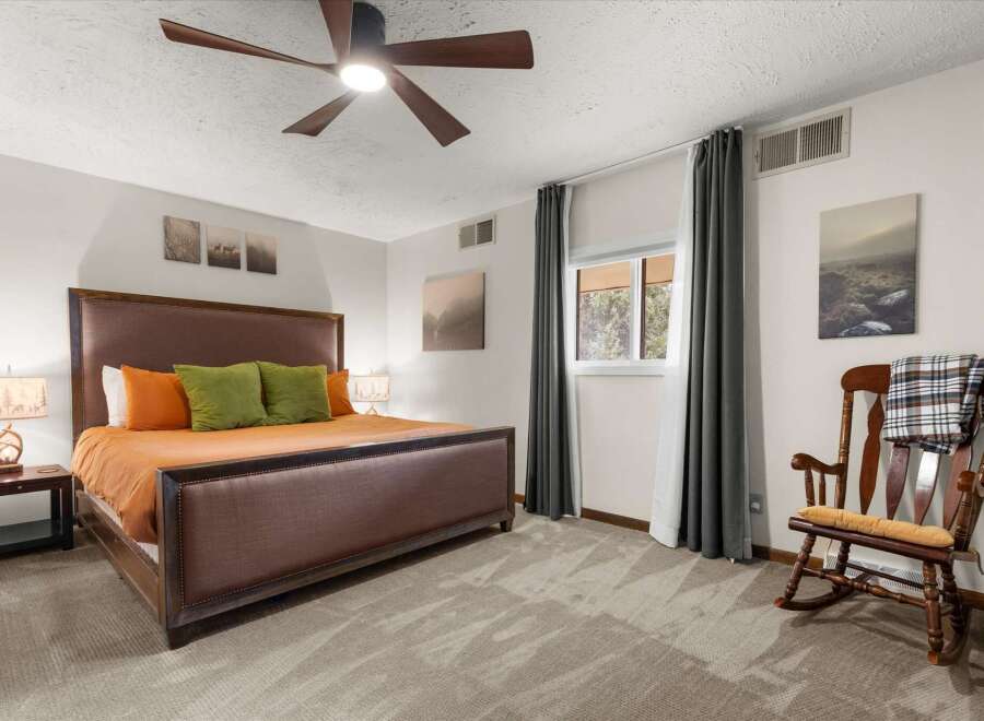 This inviting bedroom features a comfortable bed with stylish bedding and accent pillows, creating a cozy atmosphere.