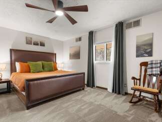 This inviting bedroom features a comfortable bed with stylish bedding and accent pillows, creating a cozy atmosphere.