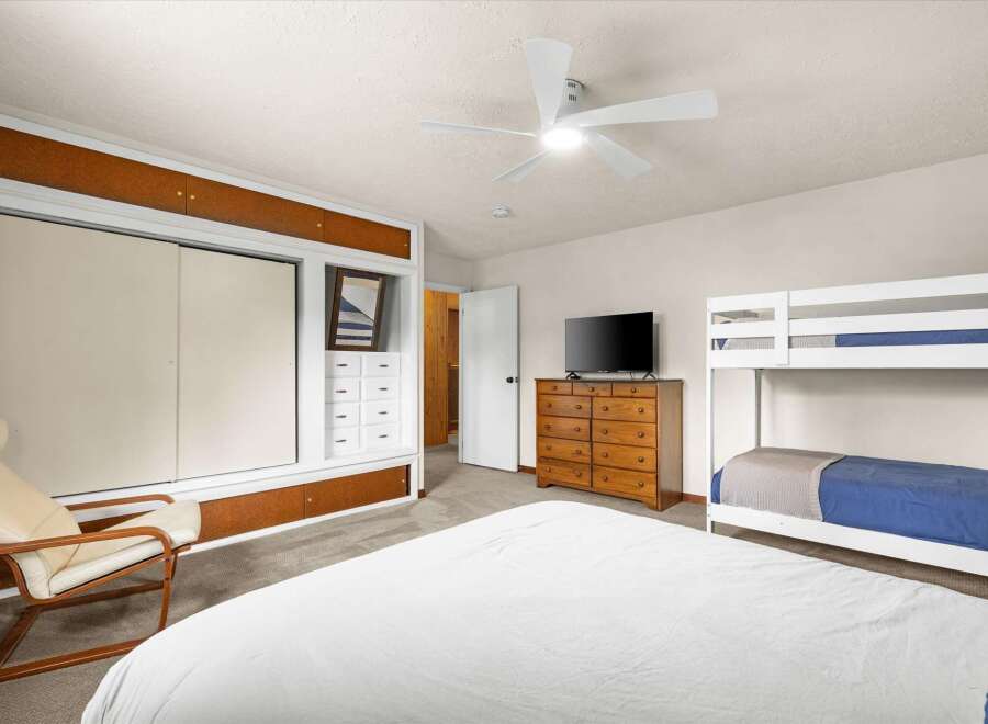 This inviting bedroom features a comfortable bed and a stylish bunk bed, perfect for accommodating guests or family.