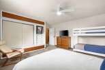 This inviting bedroom features a comfortable bed and a stylish bunk bed, perfect for accommodating guests or family.