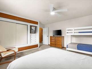 This inviting bedroom features a comfortable bed and a stylish bunk bed, perfect for accommodating guests or family.