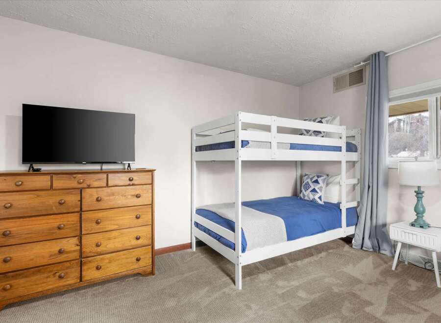 This cozy bedroom features a stylish bunk bed, perfect for accommodating guests or family members.