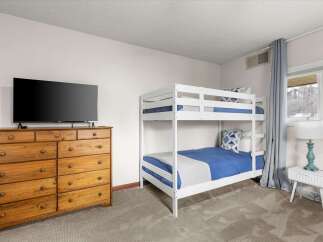 This cozy bedroom features a stylish bunk bed, perfect for accommodating guests or family members.