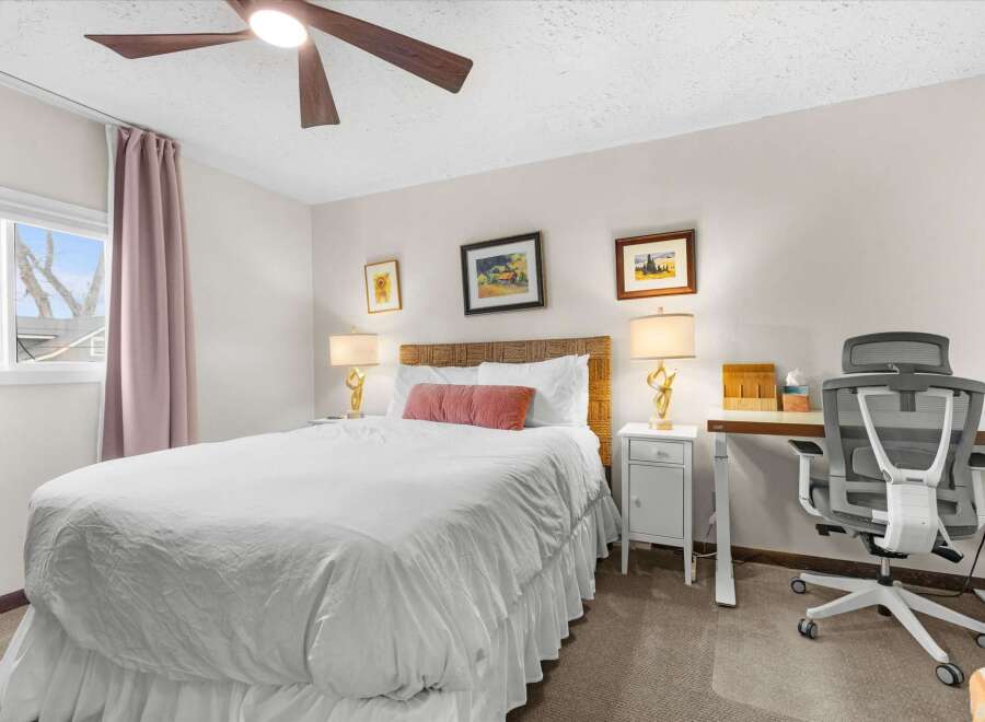 This inviting bedroom features a comfortable bed with a stylish headboard and elegant lamps.