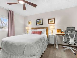 This inviting bedroom features a comfortable bed with a stylish headboard and elegant lamps.