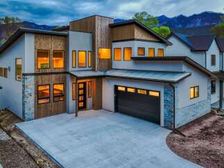 This stunning modern home boasts a striking exterior with a combination of wood and stone accents.