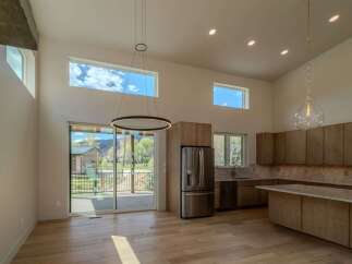 This stunning modern kitchen boasts high ceilings and an open floor plan, perfect for entertaining.