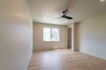 Step into this bright and airy room, featuring beautiful hardwood floors and a modern ceiling fan.