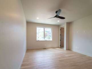Step into this bright and airy room, featuring beautiful hardwood floors and a modern ceiling fan.
