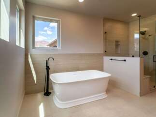 Indulge in luxury within this stunning bathroom, featuring a freestanding tub and a separate glass-enclosed shower.