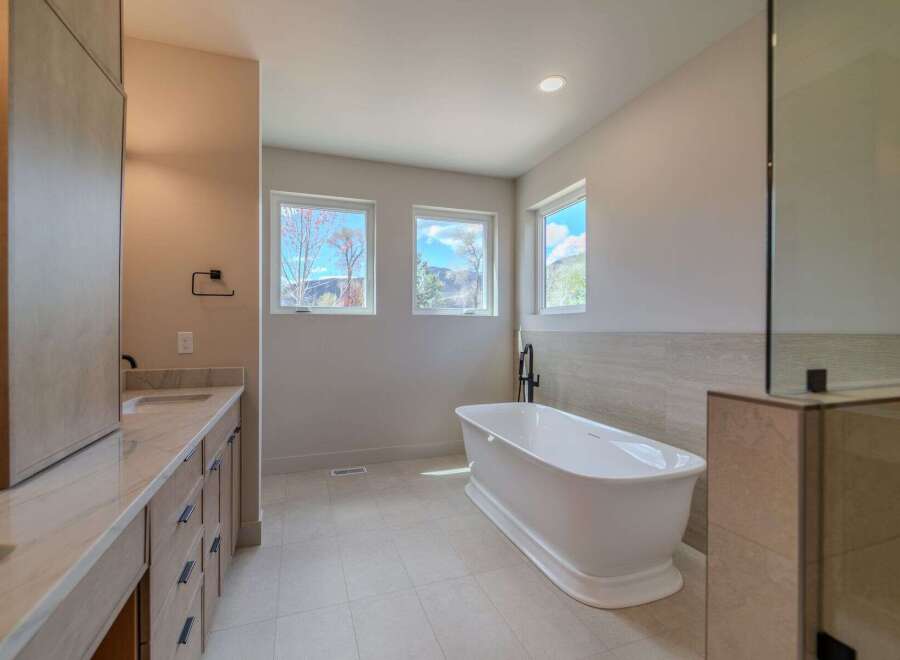 This luxurious bathroom boasts a modern design with a freestanding bathtub, perfect for relaxation.