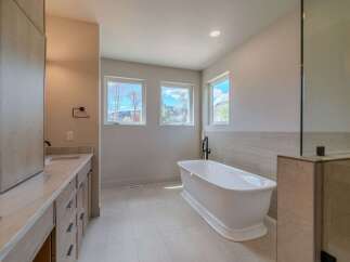 This luxurious bathroom boasts a modern design with a freestanding bathtub, perfect for relaxation.