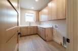 This stunning laundry room features custom cabinetry, offering ample storage space for all your needs.