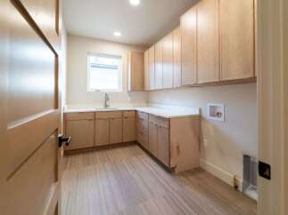 This stunning laundry room features custom cabinetry, offering ample storage space for all your needs.