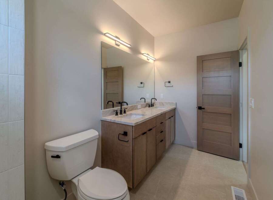 This stunning bathroom boasts a modern design with a double vanity and sleek fixtures.