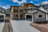 This stunning modern home boasts a striking exterior with a combination of wood and stone accents.