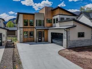 This stunning modern home boasts a striking exterior with a combination of wood and stone accents.