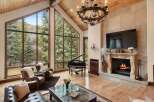 Experience luxury living in this stunning property featuring a grand piano, a cozy fireplace, and expansive windows that frame breathtaking views.