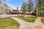 This stunning property boasts a beautiful wooden exterior and a grand driveway, perfect for luxurious living.