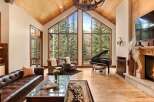 Experience luxury living in this stunning property, featuring a grand living room with soaring ceilings and expansive windows that frame breathtaking mountain views.