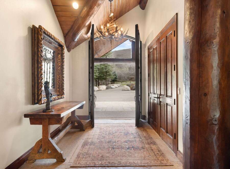 Step into luxury with this stunning entryway, showcasing a blend of rustic charm and elegant design.
