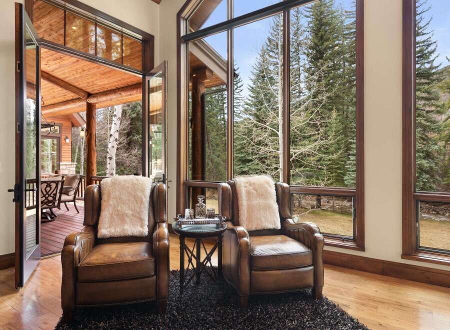 Experience the epitome of luxury living in this stunning property, featuring a serene interior with two elegant leather armchairs.